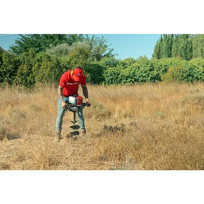 Ahoyadora DEA5200 - 1,3 kW, Anchura de trabajo: 25 cm, 2 tiempos - Hombre operando una ahoyadora Ducati en exteriores, perforando un agujero. La ahoyadora está diseñada para perforaciones precisas.