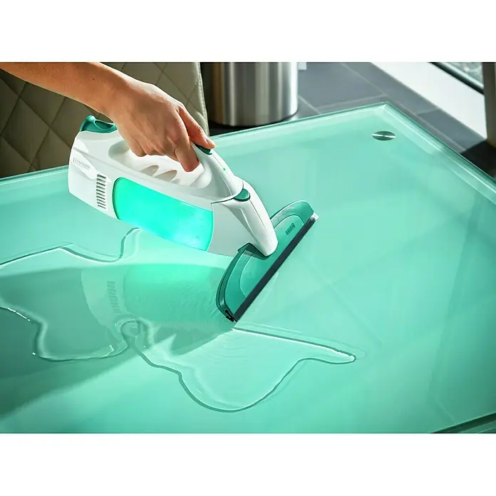 Leifheit Akku-Fenstersauger Dry & Clean - Flächenleistung: Bis 100 m²/Akkuladung, Ohne Zubehör - Ein Leifheit Fensterwischer im Einsatz auf einem Tisch. Das Gerät ist weiß und grün und hinterlässt eine saubere Oberfläche.
