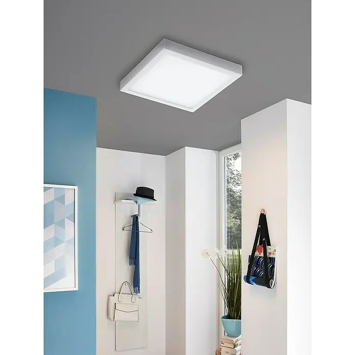 Eglo Connect LED-Deckenleuchte Fueva-C - 21 W, L x B x H: 30 x 30 x 4 cm, Weiß, Tageslichtweiß - Eine moderne, quadratische Deckenleuchte mit einem schlanken, weißen Rahmen, die helles, gleichmäßiges Licht in einem Flur spendet.