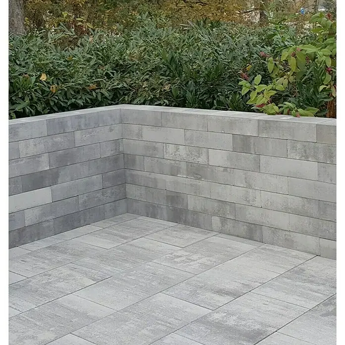 Seesteiner Mauerstein Linea - 45 x 22,5 x 12 cm, Anthrazit, Beton - Bild einer grauen Steinmauer und Bodenbelags im Freien, die eine moderne Gartengestaltung zeigen.\n