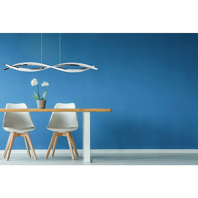 WOFI Idana LED-Pendelleuchte - Höhe: 150 cm - Hängelampe im modernen Stil über einem Esstisch mit weißen Stühlen und einer Vase mit Blumen vor einer blauen Wand.