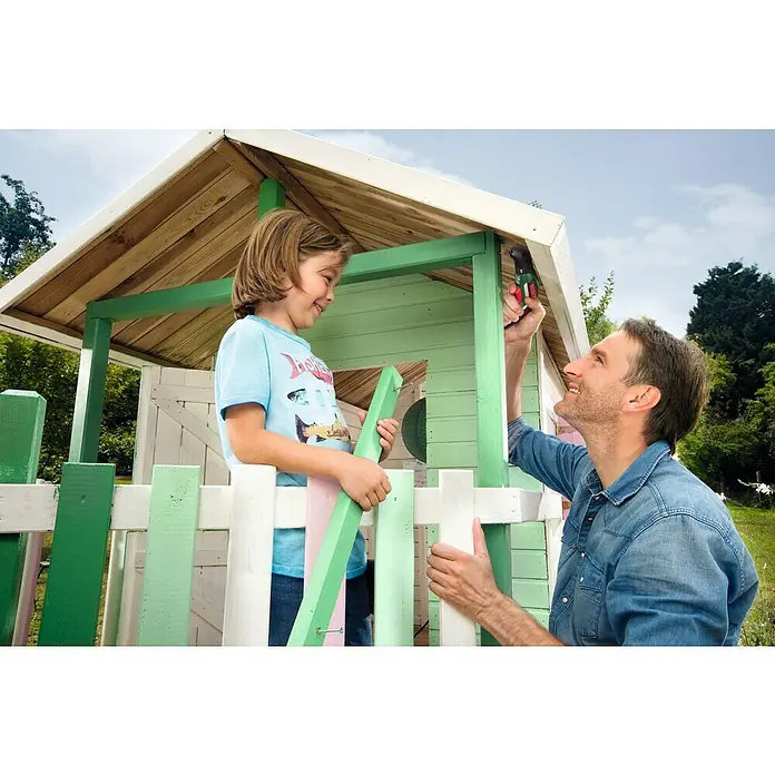 Bosch Akkuschrauber IXO V Full Set - 3,6 V, 1 Akku, 1,5 Ah, Leerlaufdrehzahl: 0 U/min - 215 U/min, 14 -tlg. - Ein Vater und sein Sohn bauen zusammen ein hölzernes Spielhaus, wobei der Vater einen Akkuschrauber benutzt und der Sohn ein grünes Holzstück hält.