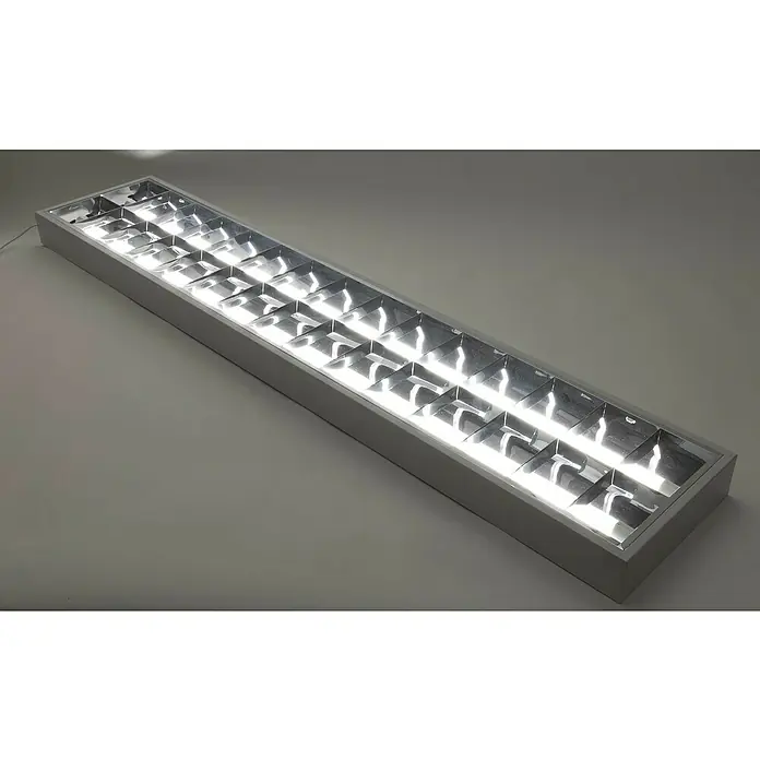 Ritter Leuchten Bürobeleuchtung Profiline - 2-flammig, 2 x 23 W, Weiß - Nahaufnahme einer langen, rechteckigen Bürolampe mit einer weißen Umrandung und mehreren quadratischen Fächern, die helles Licht ausstrahlen.