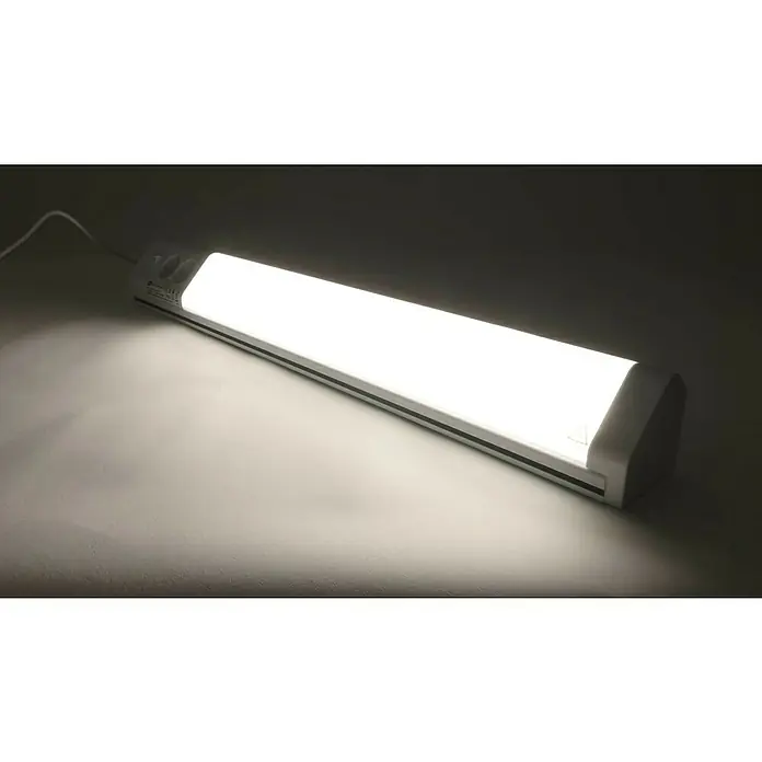 Ritter Leuchten LED-Unterbauleuchte Penta - 15 W, L x B x H: 76 x 8,5 x 8 cm, Neutralweiß - Nahaufnahme einer leuchtenden, weißen LED-Unterbauleuchte mit sichtbarem Netzkabel, die auf einer Oberfläche befestigt ist und helles Licht abgibt.