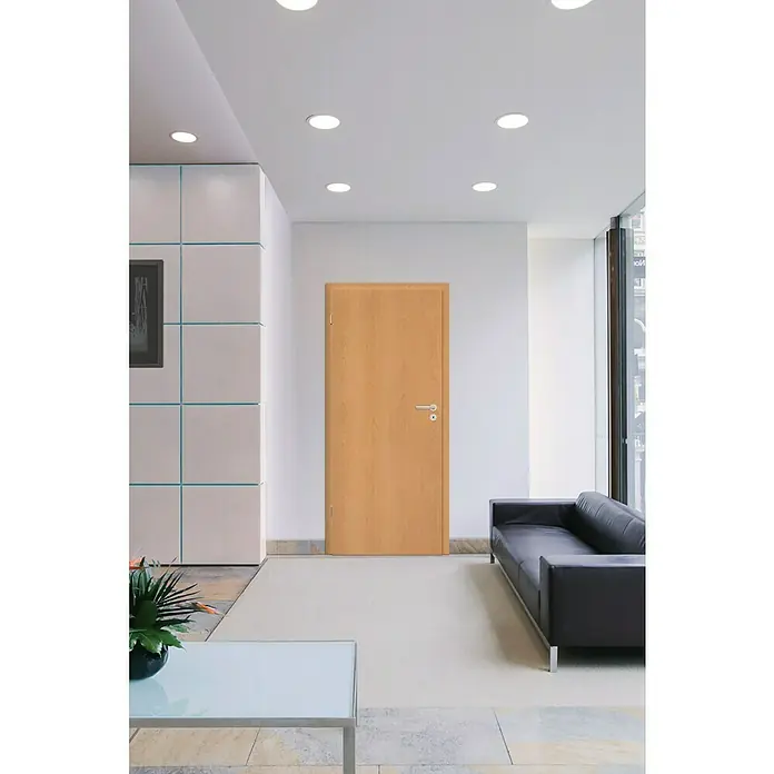 Zimmertür - 860 x 1.985 mm, DIN Anschlag: Links, Buche, Mittellage: Wabe - Elegante Holztür in einem hellen Raum. Die Tür fügt sich nahtlos in das moderne Interieur ein und strahlt Wärme und Funktionalität aus.