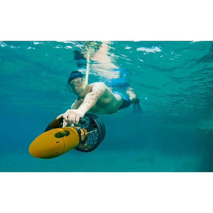 Tauchscooter - Tauchtiefe bis 30 m, Salzwasserbeständig - Ein Mann taucht mit einem gelben Unterwasser-Scooter im klaren, blauen Wasser und genießt das Unterwassererlebnis.