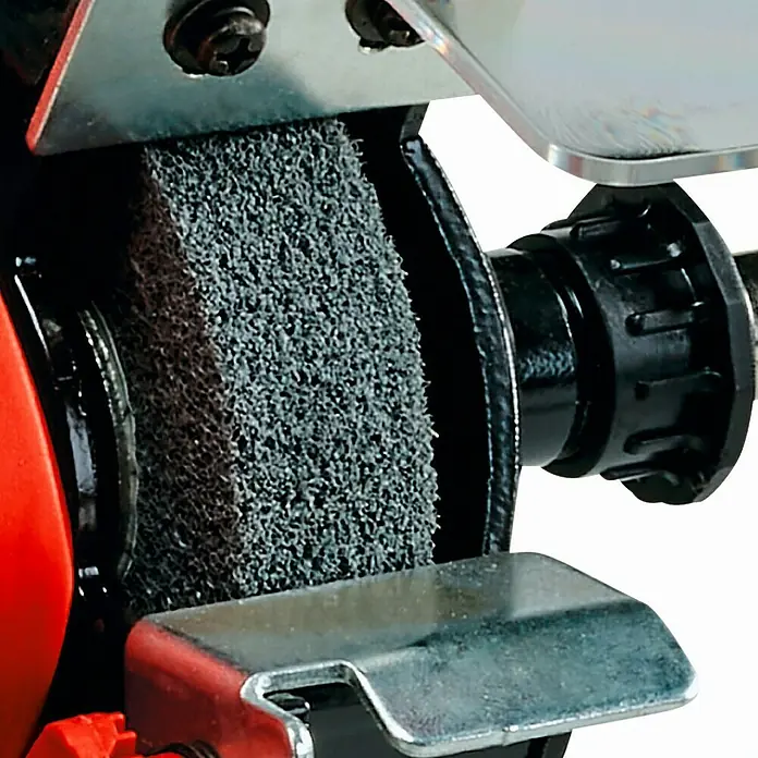 Einhell Esmeriladora TC-XG 75 Kit - 150 W, Diámetro muela abrasiva: 75 mm, 9.900 r.p.m. - Primer plano de una esmeriladora de banco con una muela abrasiva gruesa y detalles metálicos.