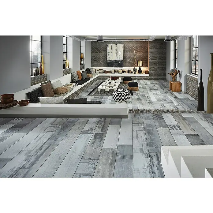 MyStyle MyDream Laminado AC6-33 Pino Native Urban - 1.285 x 192 x 14 mm, Efecto madera campestre - Vista de una sala de estar que exhibe un suelo de tablones de madera gris. El diseño natural del suelo proporciona un ambiente tranquilo a la habitación.