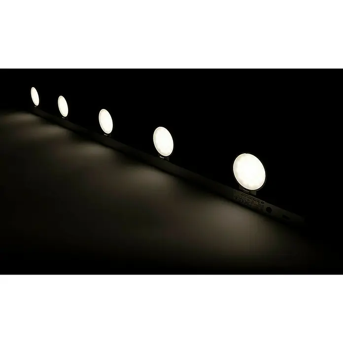Ritter Leuchten LED-Unterbauleuchte LightRacer - 15 W, Silber, L x B: 90 x 8,7 cm - Eine Reihe von runden LED-Leuchten, die an einer dunklen Leiste befestigt sind, strahlt helles Licht in einem dunklen Raum aus.