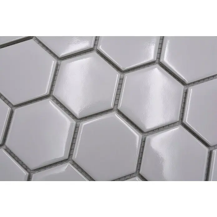 Mozaična ploščica [SI] Hexagon Uni HX 080 - 32,5 x 28,1 cm, [SI] Weiß, Sijoče - Bližnji posnetek sijajnih belih šesterokotnih ploščic, ki ustvarjajo eleganten in sodoben vzorec za stenske ali talne obloge.