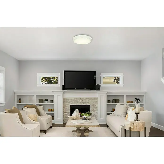 Lavida Led-plafondlamp, rond Barrea - 24 W, Ø x h: 400 mm x 10 cm, Wit - Een woonkamer met een plafondlamp, witte fauteuils en een tv boven een open haard. De plafondlamp geeft een zachte gloed.