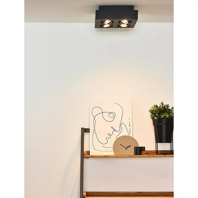 Lucide Deckenstrahler Xirax - 20 W, L x B x H: 25 x 25 x 8,8 cm, Schwarz, GU10 - Ein modernes Interieur mit einem schwarzen Deckenspot mit vier Leuchten, der den Raum beleuchtet.