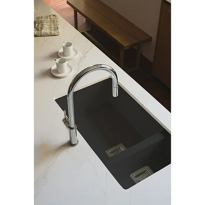 Poalgi Fregadero encastrable Zie Soft 70 - 45 x 75 cm, 1½ cubeta, Gelcoat, Negro - Primer plano de un fregadero de cocina moderno con una cubeta negra y grifo cromado sobre una encimera blanca, junto a dos tazas y una servilleta de lino.