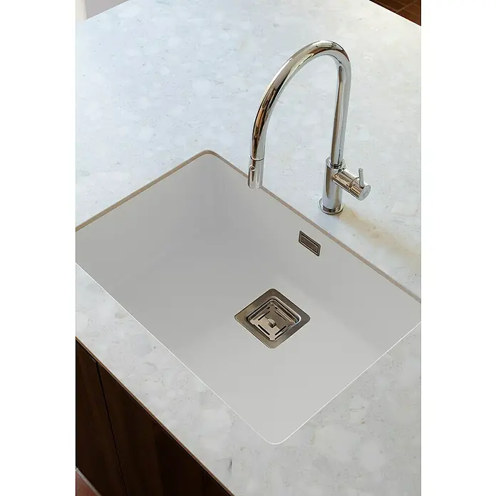 Poalgi Fregadero encastrable Zie Soft 60 - 45 x 65 cm, Gelcoat, Blanco - Un moderno fregadero de cocina hecho de material blanco con un grifo cromado brillante, incrustado en una encimera marmolada.