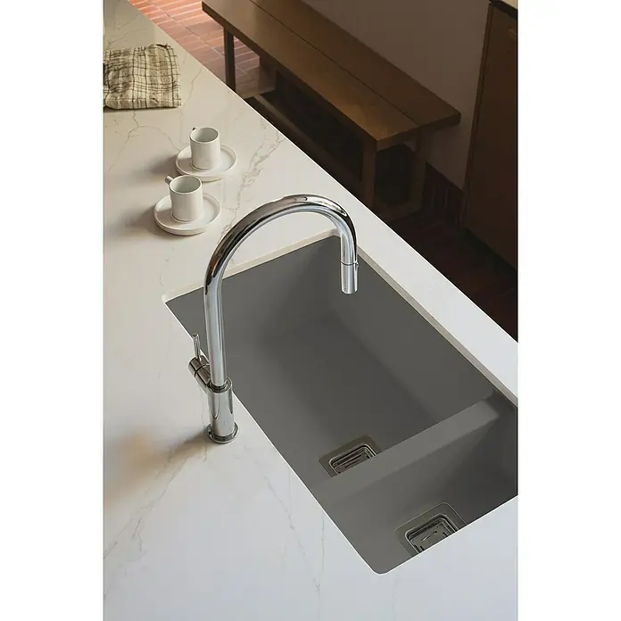 Poalgi Fregadero encastrable Zie Soft 70 - 45 x 75 cm, 1½ cubeta, Gelcoat, Gris - Un moderno fregadero de cocina con un elegante grifo cromado sobre una encimera de mármol, junto a tazas de café.