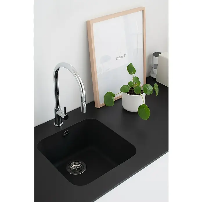 Poalgi Fregadero encastrable Gandía Soft 40 - 44,5 x 44 cm, Gelcoat, Negro - Un moderno fregadero negro con un elegante grifo cromado, complementado con una planta de interior y un marco de fotos, que muestra una cocina elegante.