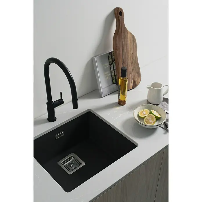 Poalgi Fregadero encastrable Zie Soft 45 - 45 x 50 cm, Gelcoat, Negro - Elegante fregadero de cocina con grifo negro y un cuenco de rodajas de limón sobre una encimera clara.