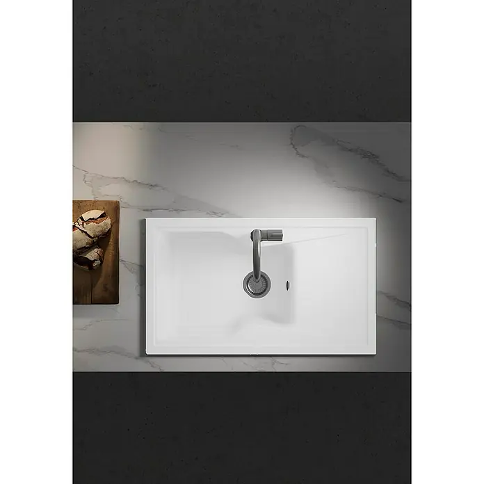 Poalgi Fregadero encastrable City 321 Soft 1S+E - 51 x 86 cm, Gelcoat, Blanco - Vista superior de un moderno lavabo rectangular con grifo, junto a una tabla de madera con pan. Diseño elegante para cualquier baño.