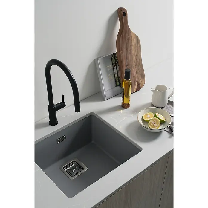 Poalgi Fregadero encastrable Zie Soft 45 - 45 x 50 cm, Gelcoat, Gris - Un fregadero de cocina moderno con grifo negro, una tabla de cortar y una botella de aceite para una cocina elegante.