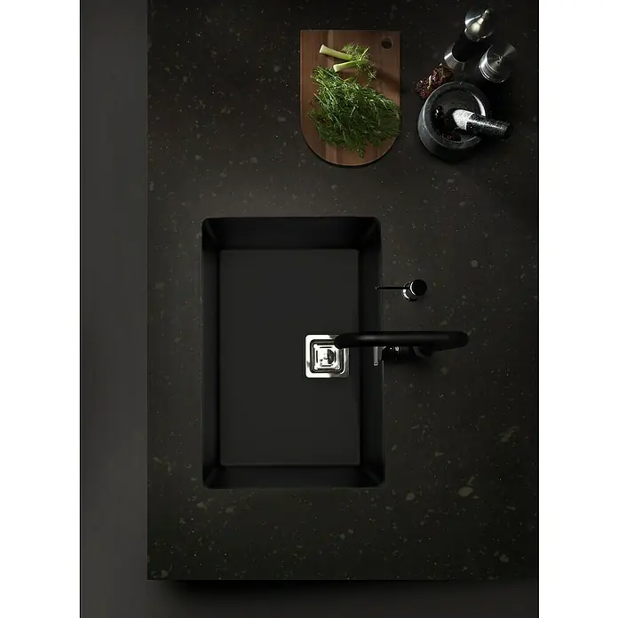 Poalgi Fregadero encastrable Zie 60 - 45 x 65 cm, Gelcoat, Negro - Fregadero oscuro con grifo en una encimera, junto con una tabla de cortar y utensilios de cocina también visibles.