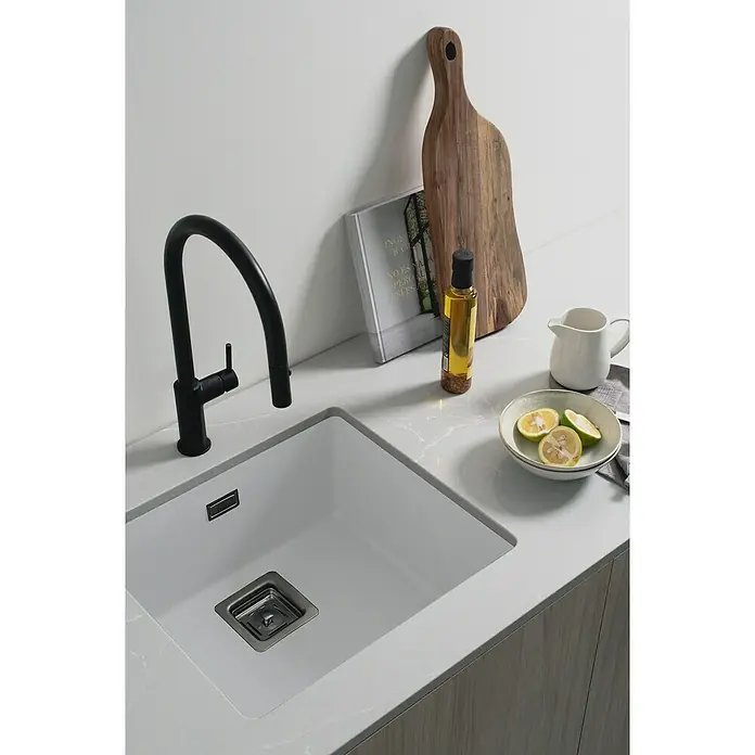 Poalgi Fregadero encastrable Zie Soft 45 - 45 x 50 cm, Gelcoat, Blanco - Primer plano de un fregadero de cocina moderno con grifo, tabla de cortar y botella de aceite sobre una encimera elegante.