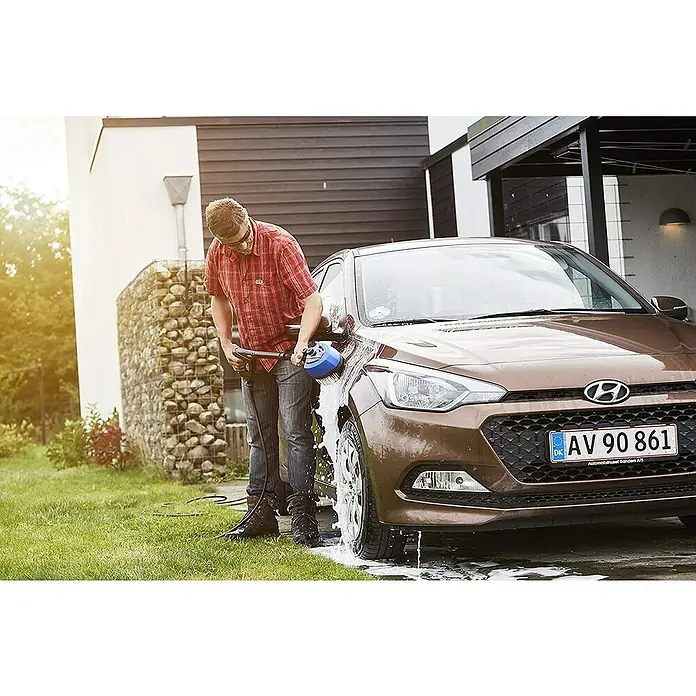 Nilfisk Detergente para automóvil Car Combi Cleaner - 2,5 l - Un hombre lavando un coche marrón con un cepillo eléctrico, con énfasis en el dispositivo de limpieza.