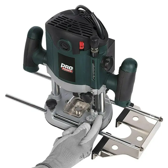 PowerPlus Fresadora de superficie POWP6050 - 2.100 W, Carrera máx. de fresado: 60 mm - La imagen muestra una fresadora vertical PRO POWER, una herramienta para trabajar la madera, ajustada por una mano con un guante de trabajo.