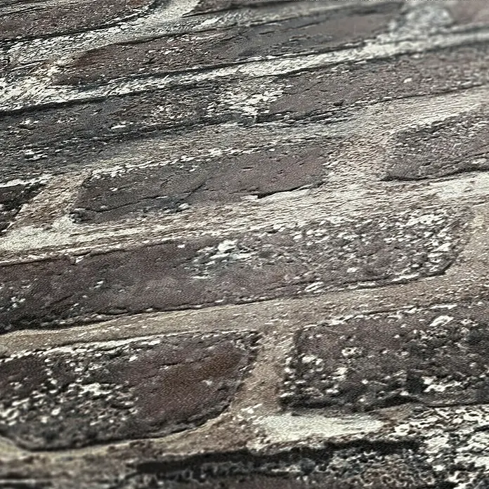 AS Creation Elements Vliestapete Steine III - Steingrau, Steinoptik, 10,05 x 0,53 m - Nahaufnahme einer Ziegelwandtapete in dunklen Farben mit weißlichen Akzenten.