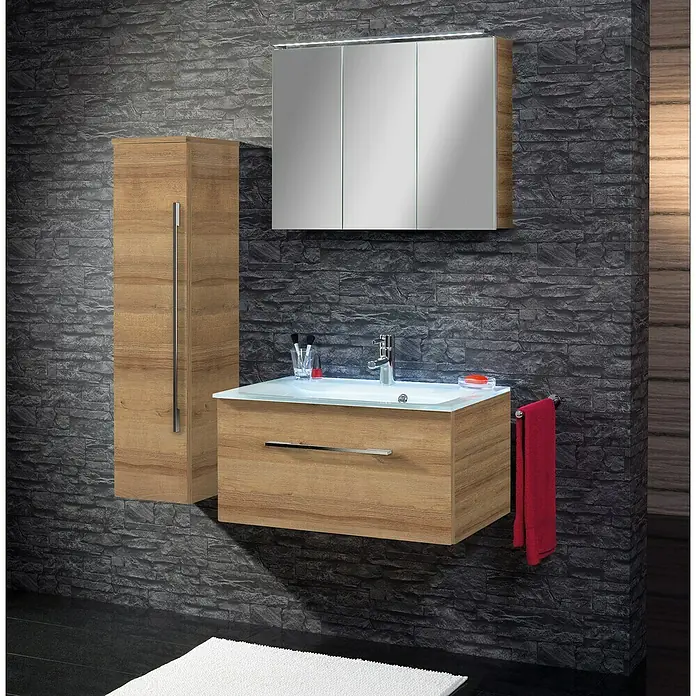 Camargue Stella LED-Spiegelschrank - B x H: 80 x 68,4 cm, Mit Beleuchtung, Spanplatte, Berg Eiche - Badezimmer-Interieur mit Waschtischunterschrank, Spiegelschrank und Hochschrank in Holzoptik vor einer dunklen Steinwand.
