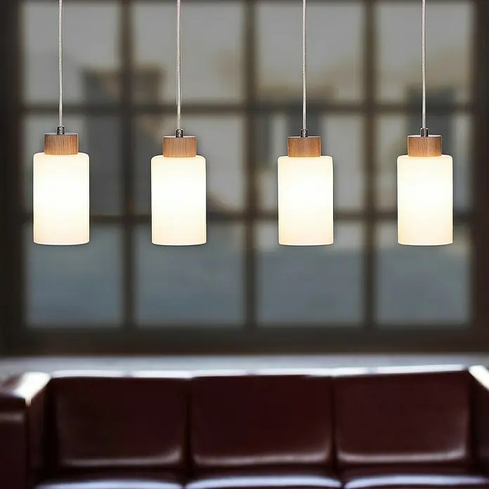 Spotlight Pendelleuchte Bosco - 60 W, L x B x H: 75 x 9,5 x 110 cm, Geölte Eiche/Transparent/Weiß, E27 - Moderne Pendelleuchten mit zylindrischem Schirm und Holzdetails, die ein warmes Licht über einem Ledersofa spenden.