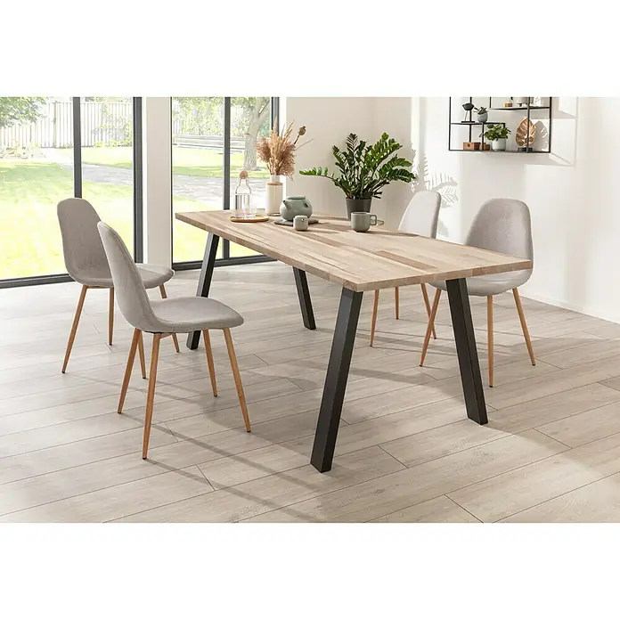 Exclusivholz Massivholzplatte - Buche, 400 x 80 x 2,7 cm - Ein Esstisch mit vier Stühlen in einem hellen Raum. Der Tisch hat eine helle Holzplatte und schwarze Beine, die Stühle sind grau mit hellen Holzbeinen.