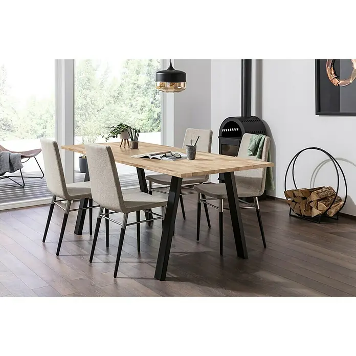 Exclusivholz Massivholzplatte - Eiche, 260 x 63,5 x 2,6 cm - Ein Esstisch aus hellem Holz mit schwarzen Beinen und vier Stühlen in einem modernen Esszimmer mit Kamin und Holzlagerung.