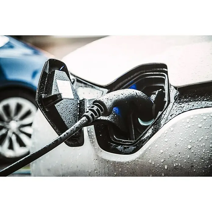 LRT E-Auto Ladestation Wallbox Home Essential + - 11 kW, 16 A - Elektroauto wird bei Regen aufgeladen. Das Ladekabel ist an den Ladeanschluss des Fahrzeugs angeschlossen.