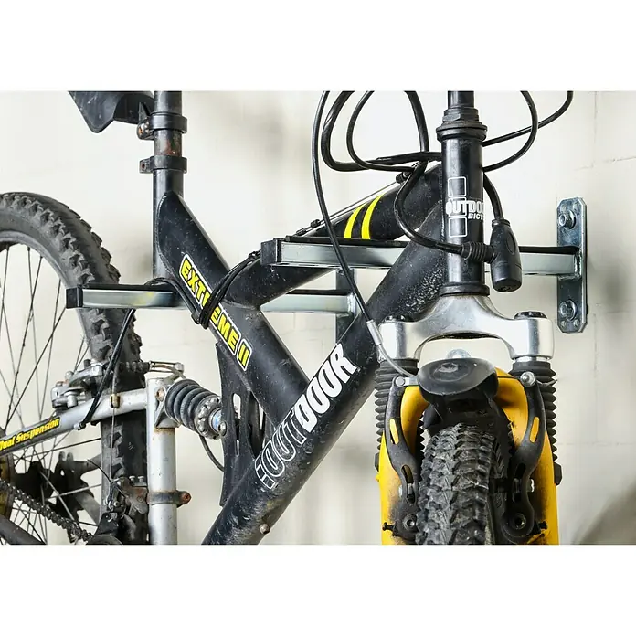 UBB Railconsole - Profiel: 27/18, Lengte: 300 mm - Een close-up van een fietsenrek dat aan een muur is gemonteerd, met een fiets eraan hangend.