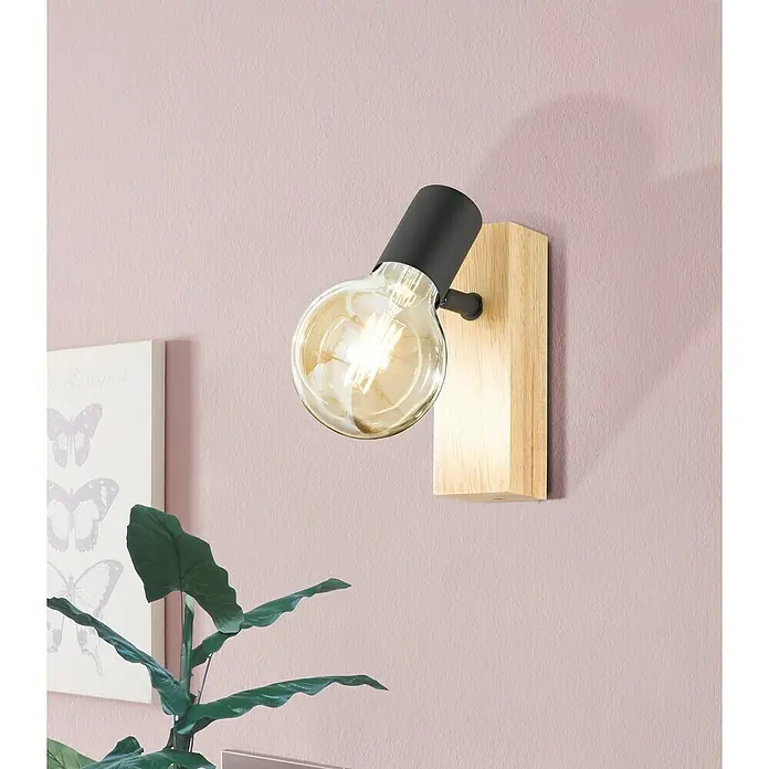 Eglo Townshend 3 LED-Wandleuchte - 10 W - Nahaufnahme einer modernen Wandleuchte mit einer Edison-Glühbirne und einem Holzsockel vor einer rosafarbenen Wand.