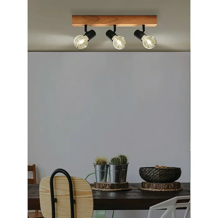 Eglo Townshend 3 Deckenstrahler - 180 W, L x B x H: 5 x 5 x 48 cm, E27 - Deckenleuchte mit drei Strahlern an einem Holzsockel über einem Esstisch mit Kakteen und Schale.