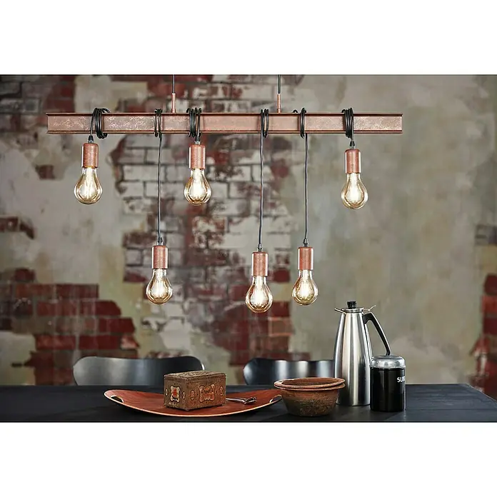 Eglo Townshend Pendelleuchte - B x H: 7 x 110 cm, Antik Braun - Eine industrielle Hängeleuchte mit sechs Edison-Glühbirnen und Kupferdetails, die über einem Esstisch hängt.