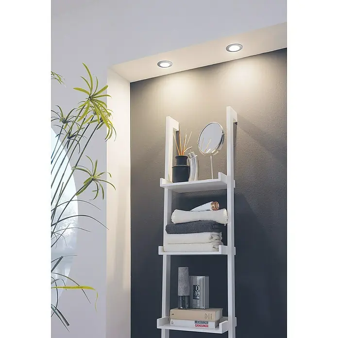Eglo LED-Einbauleuchte Pineda - 6 W, L x B x H: 8,4 x 8,4 x 4 cm, Chrom, Warmweiß, Dimmbarkeit: Dimmbar - Regal mit Handtüchern, Kosmetikartikeln und Dekorationen, beleuchtet durch Deckenleuchten. Das helle Holzregal kontrastiert schön mit der dunklen Wand im Hintergrund.