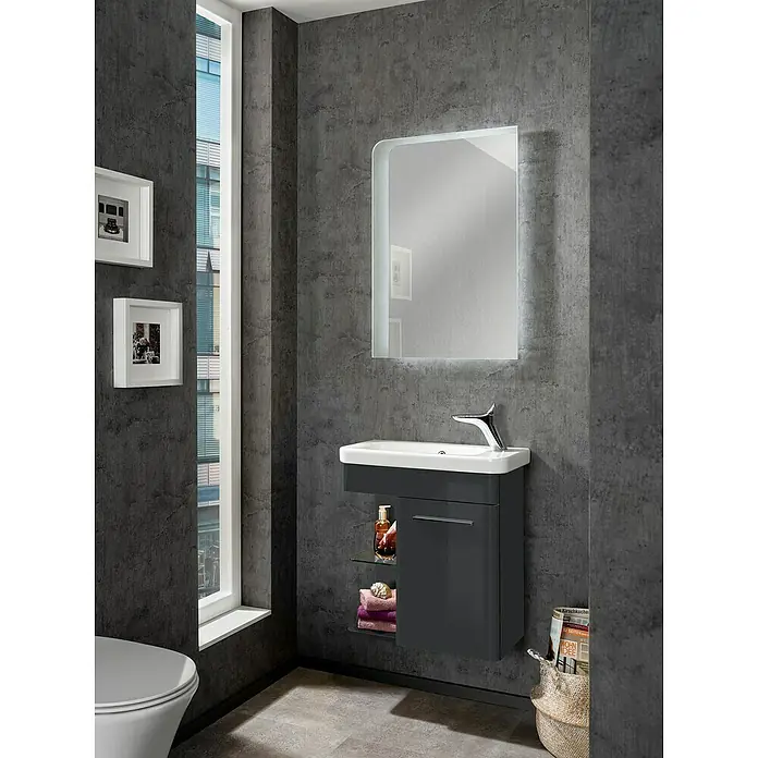 Camargue Faro Mini Waschtischunterschrank - 55 x 29,5 x 55 cm, Bewegungsmelder mit LED-Beleuchtung, Grafit - Badezimmer-Interieur mit einem grauen Waschtischunterschrank mit einer weißen Spüle und einem beleuchteten Spiegel an einer Betonwand.