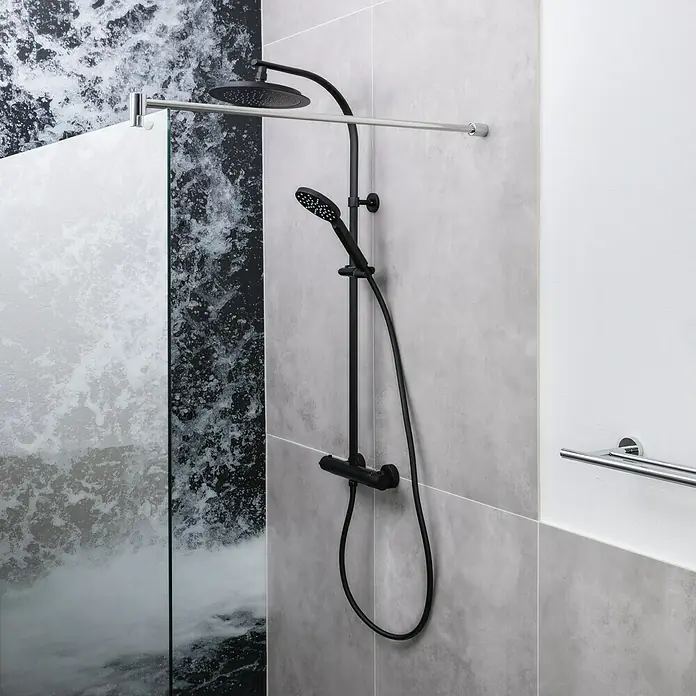 Camargue Duschsystem New York - Mit Thermostatarmatur, Anzahl Strahlarten: 3 Stk., Schwarz - Schwarze Duschgarnitur mit Regendusche und Handbrause vor grauem Fliesen- und Marmorhintergrund. Moderne Badezimmerausstattung.