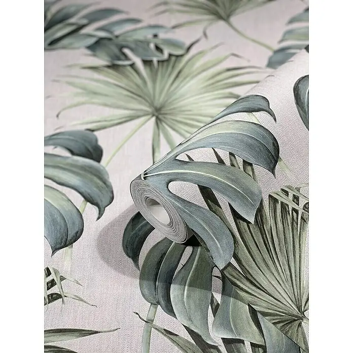 SCHÖNER WOHNEN-Kollektion New Spirit Vliestapete New Spirit - Grün/Weiß, Floral, 10,05 x 0,53 m - Nahaufnahme einer Rolle tropischer botanischer Tapete mit Monstera- und Palmenblattmustern in sanften Grün- und Grautönen.