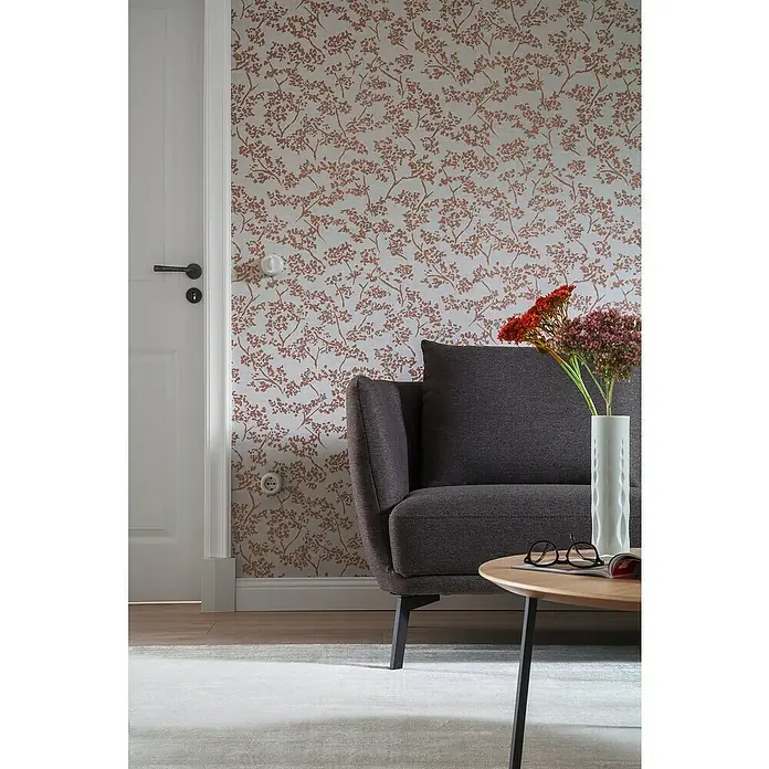 SCHÖNER WOHNEN-Kollektion New Spirit Vliestapete Struktur I - Grau/Gold, Floral, 10,05 x 0,53 m - Nahaufnahme eines modernen Wohnzimmers mit stilvollem Sofa und dekorativer Blumenvase.