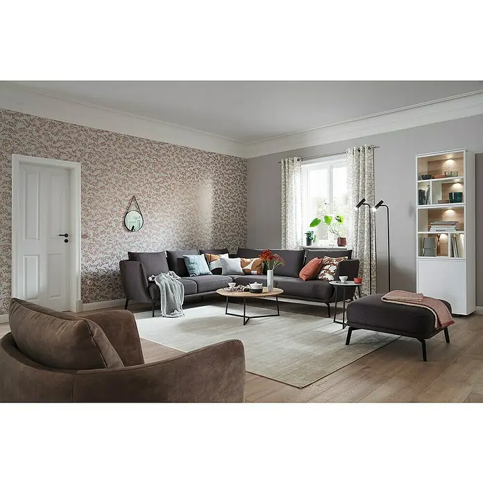 SCHÖNER WOHNEN-Kollektion New Spirit Vliestapete Struktur I - Grau/Gold, Floral, 10,05 x 0,53 m - Wohnzimmer mit grauer Eckcouch, Couchtisch, Sessel und Bücherregal. Gemütliches Ambiente mit stilvoller Einrichtung und floraler Tapete.